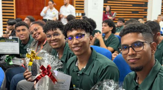 Imagen de chicos sosteniendo en sus manos elementos de premiación Hackathon dia 3