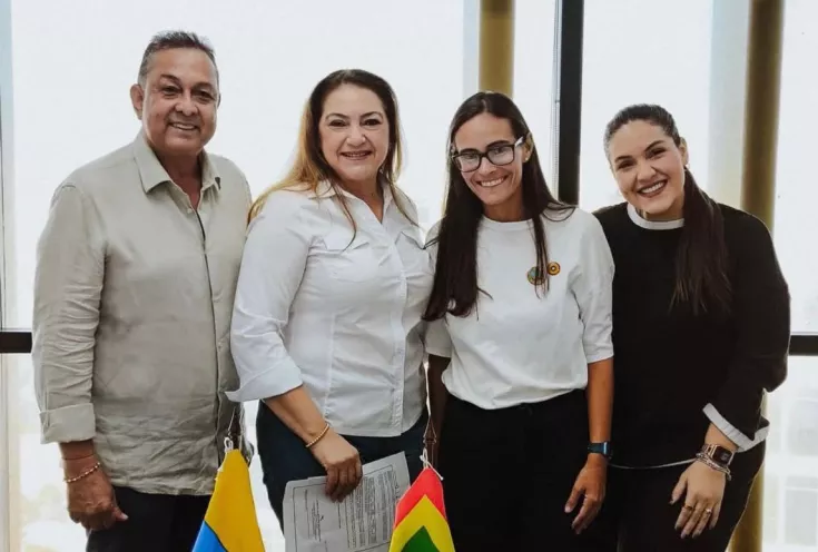Foto de persnas recibiendo la nacionalidad colombiana en comapañía de la directora de la oficina de Cooperación Internacional