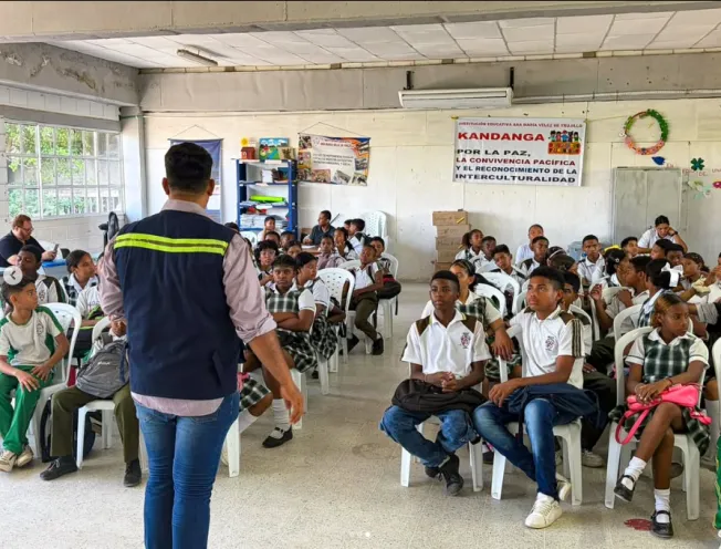 Facilitador impartiendo una charla sobre derechos sexuales y reproductivos a un grupo de estudiantes sentados en el salón de una institución educativa.