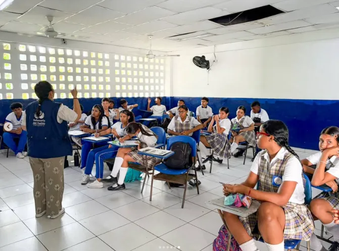 Delegada de la Defensoría del Pueblo impartiendo una charla sobre derechos y participación a estudiantes en el salón de clases de una institución educativa