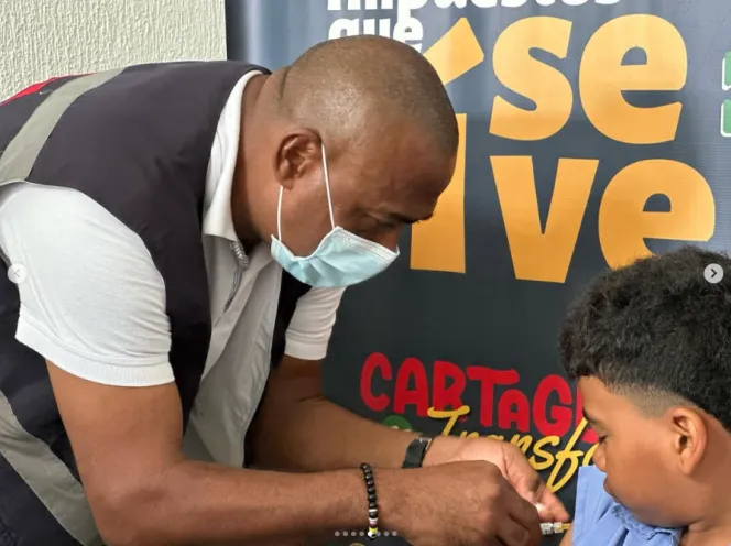 Funcionario del DADIS vacuna a un menor contra el dengue  