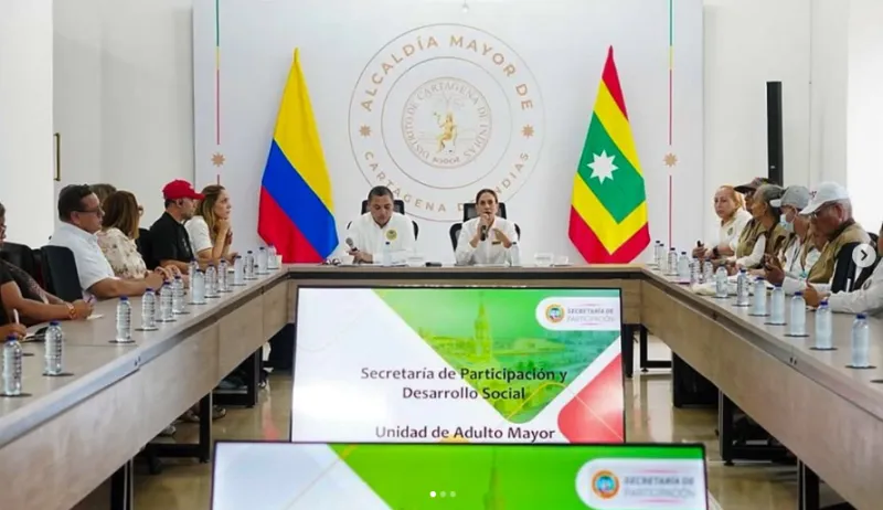 En la imagen se aprecia una amplia mesa de juntas donde un grupo de funcionarios y representantes ciudadanos asisten de manera presencial a una sesión institucional.
