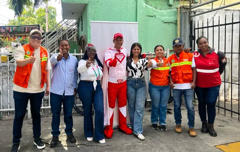 En la imagen se observa a un grupo de personas sonrientes, incluyendo a varios trabajadores y un personaje disfrazado de capitán aseo , posando juntos al aire libre durante la jornada de limpieza.
