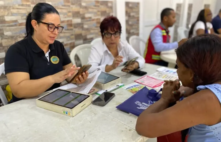 Funcionarios de la Alcaldia Local 1 atienden a los habitantes del barrio Amberes en una mesa de trabajo institucional, mientras una ciudadana recibe asesoria directa.